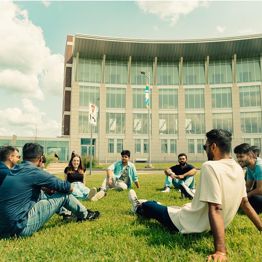 Students sit in circle on Campus Center Lawn.